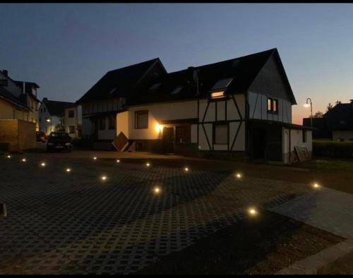 una casa con muchas luces delante de ella en B&B Malú am Ring en Müllenbach