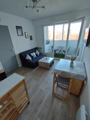 un salon avec un canapé et une table dans l'établissement Le charme de Cabourg, à Cabourg