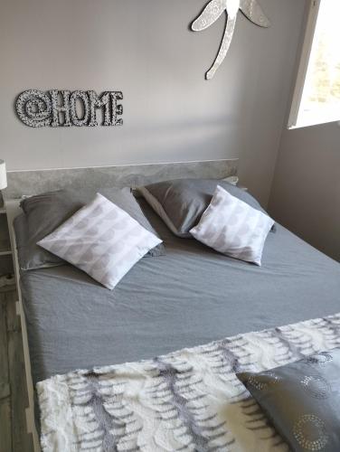 - un lit avec 2 oreillers et un panneau mural dans l'établissement Le charme de Cabourg, à Cabourg