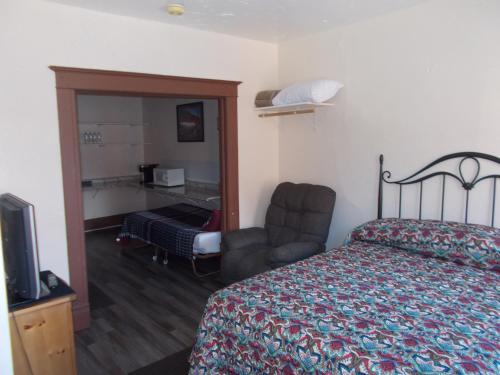 ein Hotelzimmer mit einem Bett und einem Stuhl in der Unterkunft Kellogg Rio Hotel in Kellogg