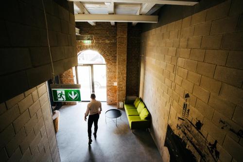 a man walking down a hallway in a room with a couch at Smaltovňa Lofty in Lučenec