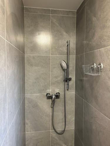 a shower with a shower head in a bathroom at Dovolenkový dom Púpava in Terchová