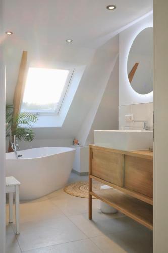 a bathroom with a white tub and a sink at Helles modernes City-Loft in Freudenstadt
