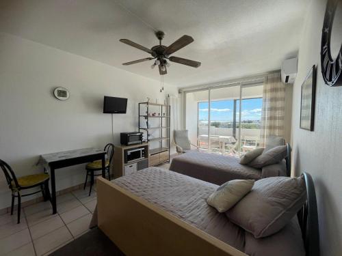 une chambre avec un lit et un bureau avec une fenêtre dans l'établissement Charmant T2 avec balcon, clim et animaux admis à Balaruc-les-Bains - FR-1-503-85, à Balaruc-les-Bains