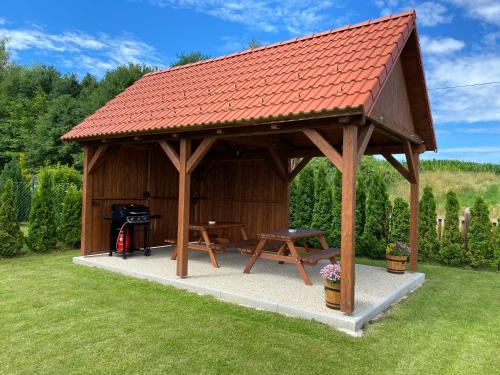 a wooden gazebo with a picnic table and a grill at Apartmány Přeseka in Třeboň