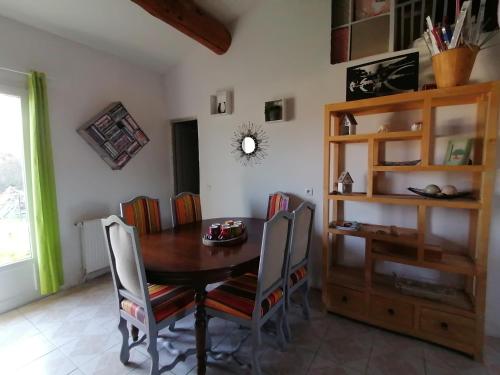 ein Esszimmer mit einem Holztisch und Stühlen in der Unterkunft Le Tavan in Crillon-le-Brave
