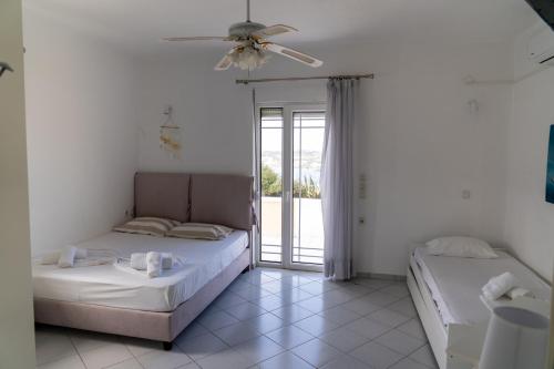 - une chambre avec 2 lits et un ventilateur de plafond dans l'établissement Villa Lygaria, à Ligaria