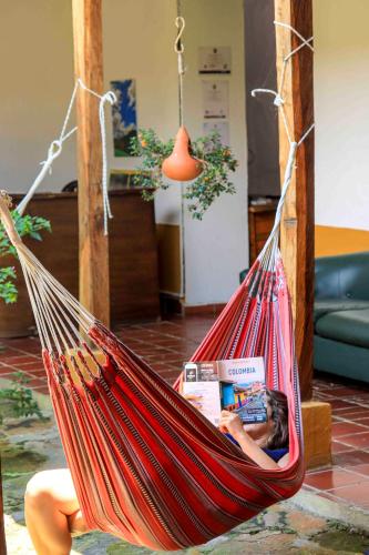 a person sitting in a hammock with a magazine at La Hacienda in San Gil