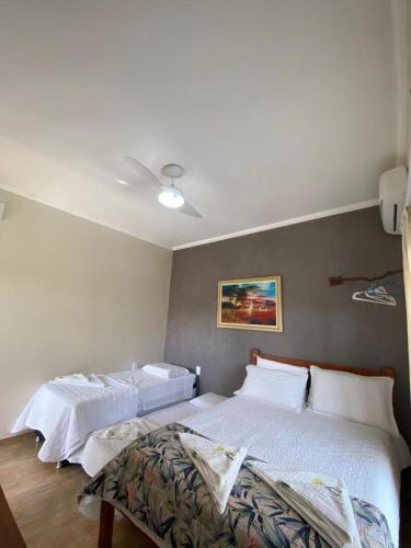 a bedroom with two beds and a ceiling at Residencial Águas de Bare in São Sebastião