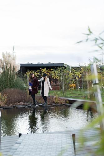 two people walking on a bridge over a pond at Life Contains Beautiful Things in Almere