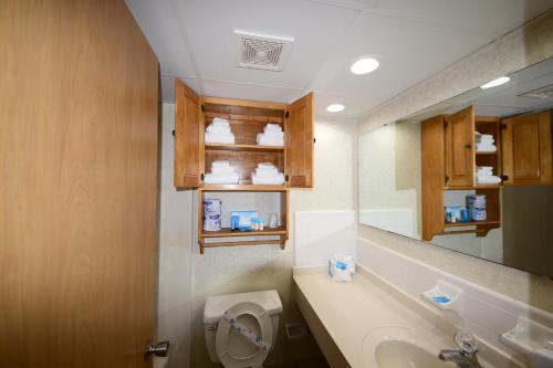 a bathroom with a toilet and a sink and a mirror at Holiday Sands North "On the Boardwalk" in Myrtle Beach
