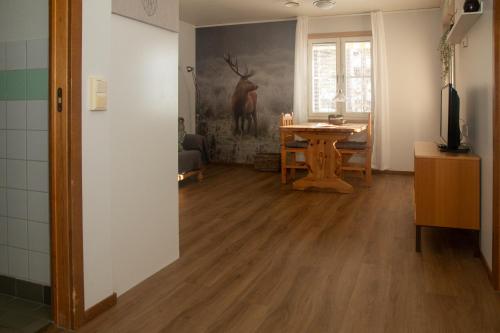 uma sala de estar com uma mesa e uma pintura de veado na parede em HusHotellHunge AB em Bräcke