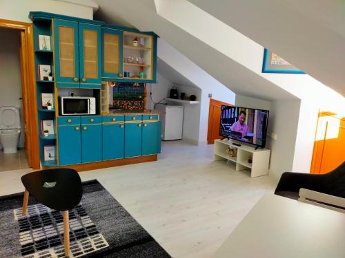 a living room with blue cabinets and a tv at Apartamento en el casco antiguo de Ponferrada in Ponferrada