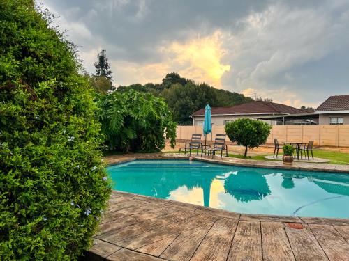 a swimming pool with a table and chairs in a yard at Aerodrome Lodge and Conference Centre in Benoni