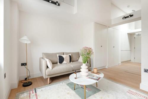 ein Wohnzimmer mit einem Sofa und einem Tisch in der Unterkunft Notting Hill Gate Residence VI in London