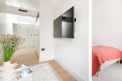 a bedroom with white walls and a tv on the wall at Notting Hill Gate Residence VI in London