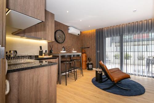 a kitchen with a counter and chairs in a room at Marinha Grande Apartamentos N4 FACTORY in Marinha Grande
