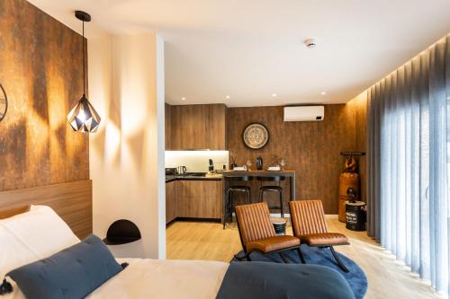 a bedroom with a bed and a kitchen with a table at Marinha Grande Apartamentos N4 FACTORY in Marinha Grande