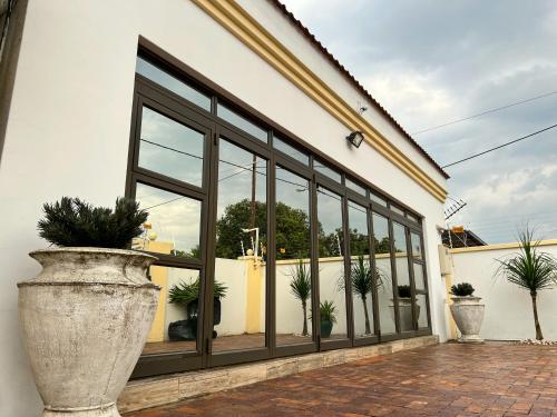 a building with large windows and potted plants at Aerodrome Lodge and Conference Centre in Benoni