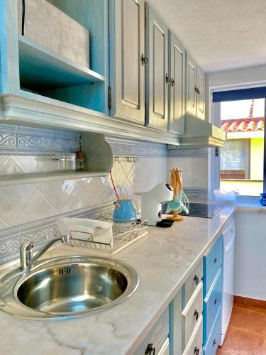 a kitchen with a sink and blue cabinets at A Berlenga 3 in Nazaré
