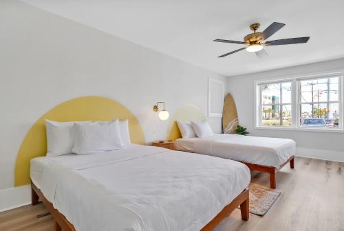 a bedroom with two beds and a ceiling fan at The Starlite Inn in Carolina Beach