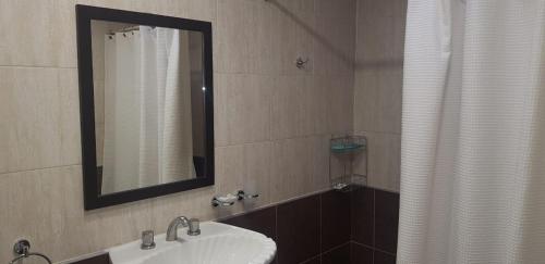 a bathroom with a sink and a mirror at Casa calida y acogedora, Capital Mendoza in La Cieneguita