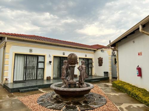 a statue of two people in a fountain in front of a building at Aerodrome Lodge and Conference Centre in Benoni