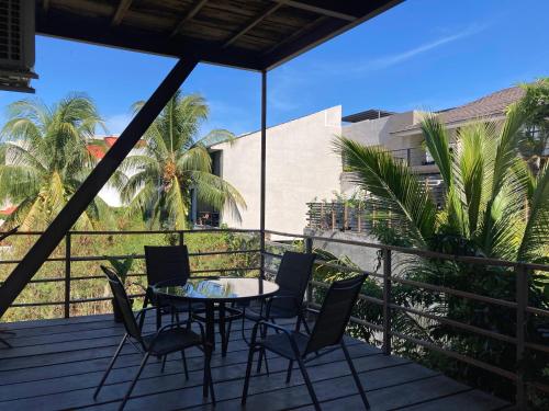 a patio with a table and chairs on a deck at Palmas de Chahue in Santa Cruz Huatulco