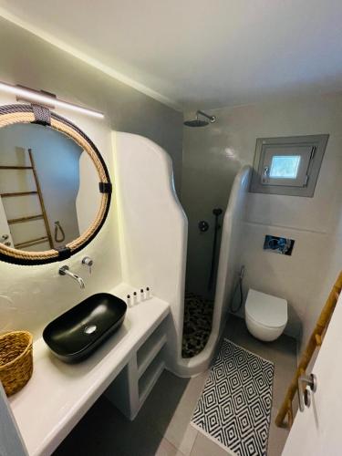 a small bathroom with a sink and a mirror at Egea House in Stelida