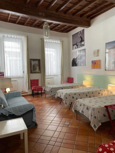 ローマにあるPiazza Farneseのベッド数台、椅子、窓が備わる客室です。