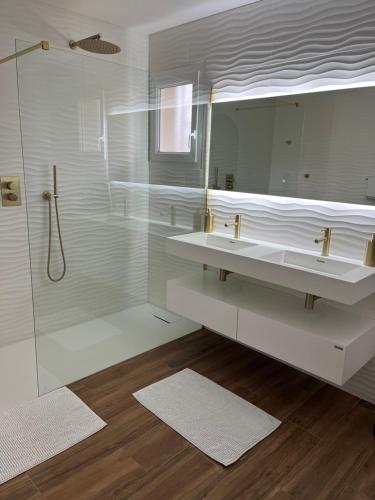 a white bathroom with two sinks and a shower at Chambres d'Hôtes Villa La Louisiane in Arès