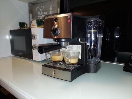 a coffee maker sitting on a counter with two glasses at Royal Place Apartment - East Sarajevo in Lukavica