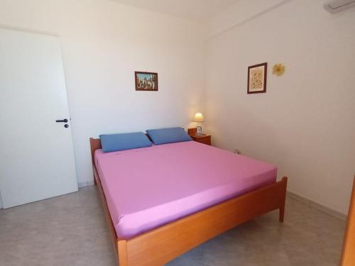 a bedroom with a bed with a purple mattress at Blue Sea Apartment in Punta Braccetto