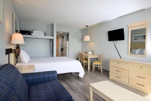 a hotel room with a bed and a couch and a table at Holiday Sands North "On the Boardwalk" in Myrtle Beach