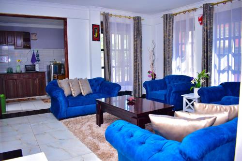 salon z niebieskimi kanapami i stolikiem kawowym w obiekcie Rozy Penthouse w mieście Kisumu