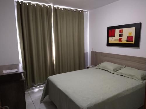 a bedroom with a bed and a window with curtains at Riviera Thermas Park in Caldas Novas