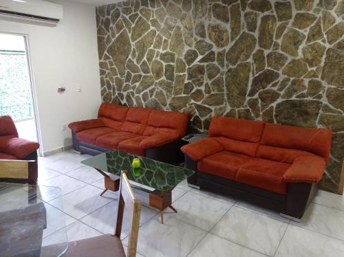 a living room with two couches and a table at Palmas de Chahue in Santa Cruz Huatulco