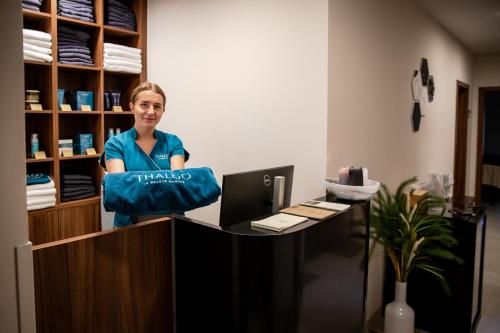 a woman sitting at a desk with a pillow at Zámek Třešť in Třešť