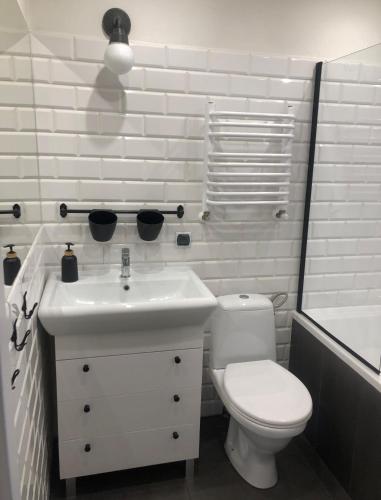a white bathroom with a toilet and a sink at Apartament Śródmieście Krosno in Krosno