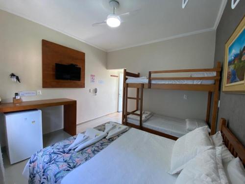 a bedroom with two bunk beds and a desk at Residencial Águas de Bare in São Sebastião