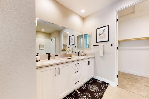 baño con armarios blancos y espejo grande en The Palm House at PGA West Permit# 260,216, en La Quinta