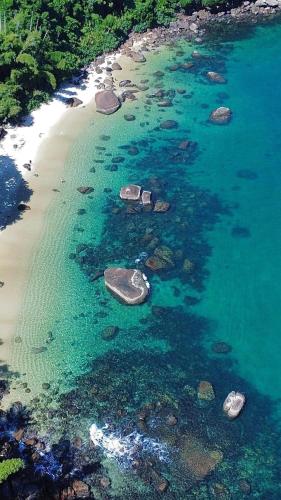 an aerial view of a beach with rocks and water at Mar Suites Praia Grande in Ubatuba