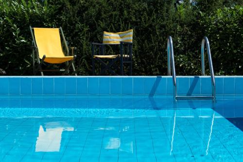 - deux chaises assises à côté de la piscine dans l'établissement La Secchia Rapita, à Zappolino