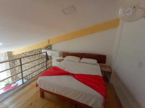 a bedroom with a bed with a red blanket on it at Palmas de Chahue in Santa Cruz Huatulco