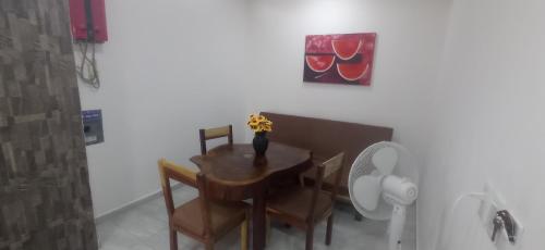a dining room table and chairs with a vase of flowers on it at Palmas de Chahue in Santa Cruz Huatulco