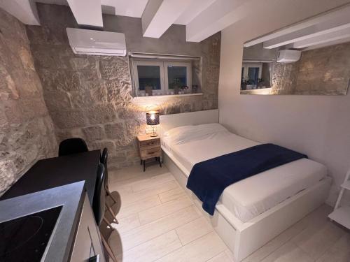 a bedroom with a bed and a desk with a television at Center Beach Apartament, Split, Croatia in Split