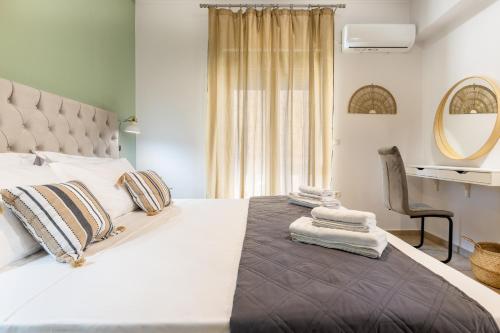 una camera con un grande letto bianco e una sedia di Blue Port in Chania a Souda (Suda)