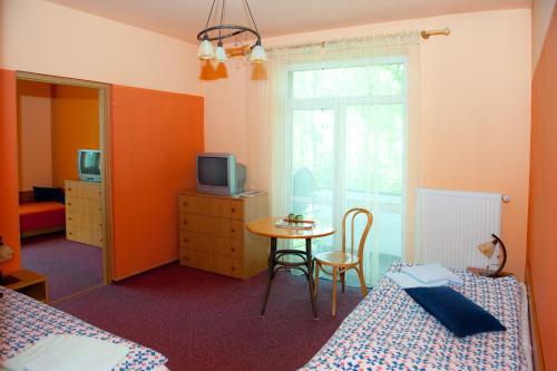 um quarto com 2 camas e uma mesa com televisão em DW Potok em Wisła