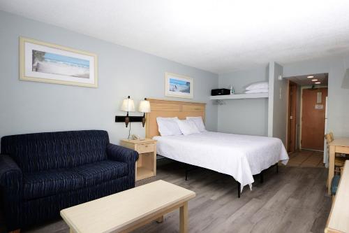 a hotel room with a bed and a couch at Holiday Sands North "On the Boardwalk" in Myrtle Beach