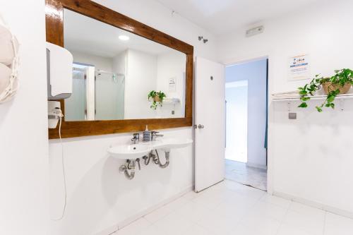 a bathroom with a sink and a mirror at La Cocotera Boutique Hostel & Coworking in Tarifa